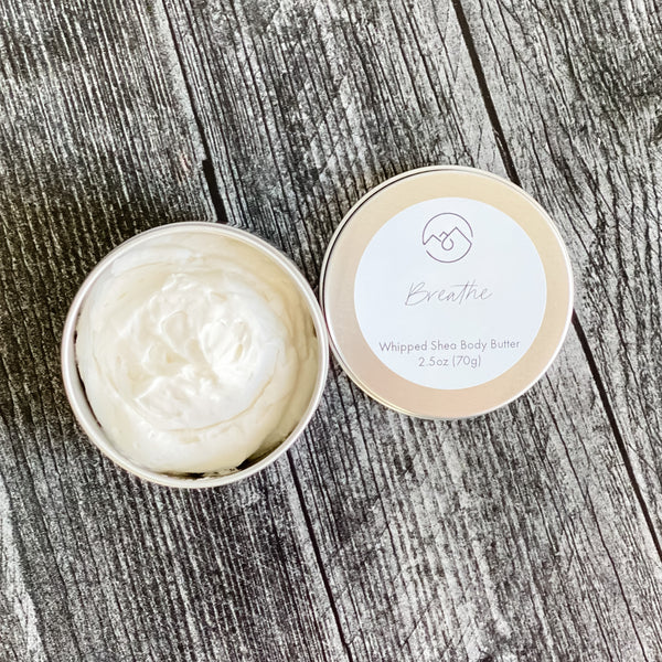 Breathe Whipped Body Butter in tin with lid next to it. Shows the creamy whipped nature of this body butter.