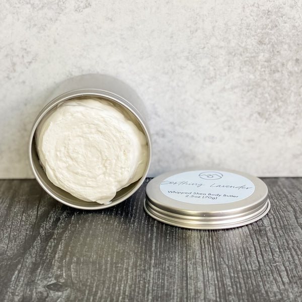 Soothing Lavender Whipped Body Butter in open tin turned on its side with lid next to it. Displays how thick and rich this body butter is.